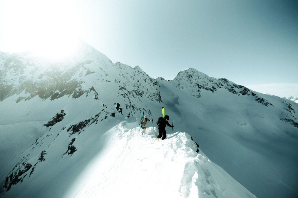 Drei Bergsteiger auf einem schneebedeckten Gipfel
