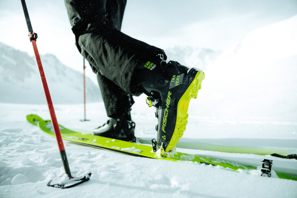 Ein Skifahrer steht auf grünen Skiern im Schnee.
