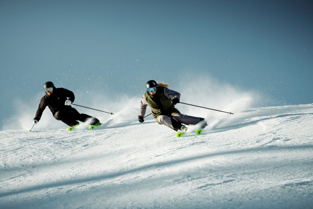 Zwei Skifahrer auf einer verschneiten Piste